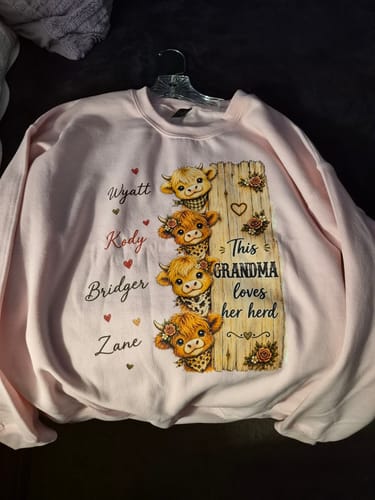 Customer's personalized light pink Highland cow sweatshirt with names Wyatt, Kody, Bridger, and Zane.
