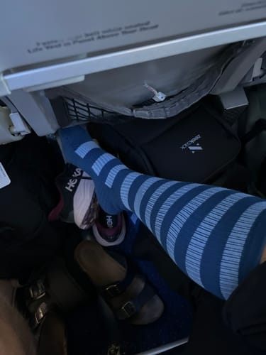 Kundens blå, randiga Diasocks stödstrumpor på under en flygresa.