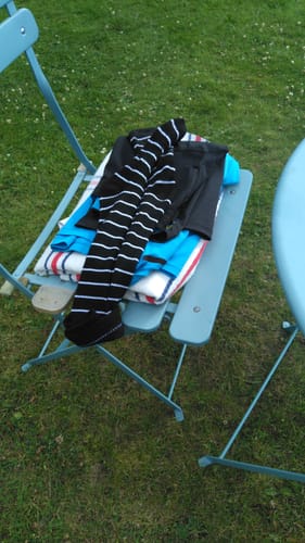 Customer's black and white striped Diasocks Stödstrumpor folded on a light blue garden chair.