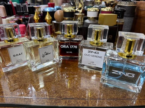 Customer's G.O.A.T fragrance bottle displayed alongside several other perfume bottles on a surface.