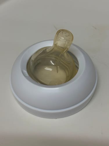 Customer's Philips Avent Classic replacement nipple in a white plastic screw ring, close-up.