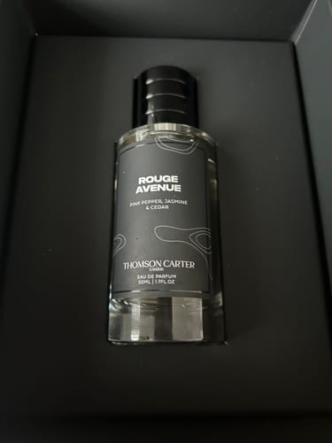 Customer's bottle of Rouge Avenue Eau de Parfum sitting securely in a dark, structured presentation box.