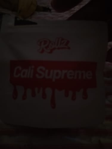 Customer's Cali Supreme branded product packaging, dimly lit.