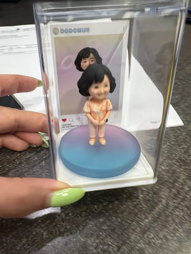 Customer's custom character figure displayed inside a Dust-Proof Acrylic Display Case on a gradient base.