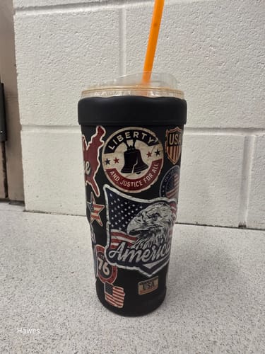 Customer's To-Go Buddy cup with patriotic eagle and Liberty bell stickers, featuring an orange straw.