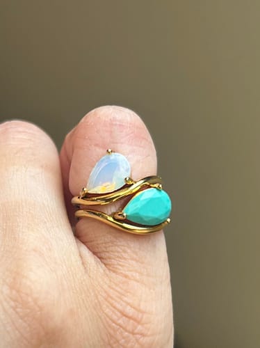 Customer's Pia Gemstone Ring, worn as a stacked set with an opal and turquoise pear-cut stone on a gold wave band.