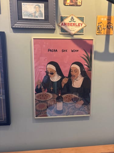 Customer's framed Holy Trinity art print hanging on a wall with other framed decor.