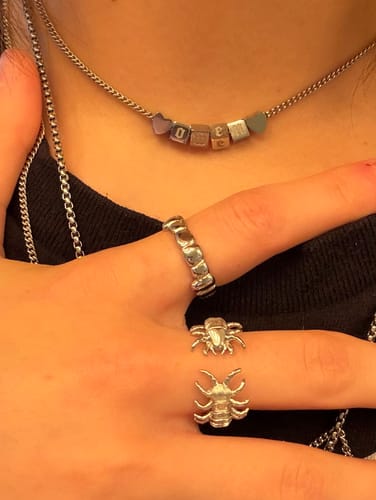 Customer's silver Grill Ring worn on a hand alongside another textured ring.