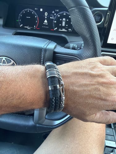 Customer's Wheat Chain Bracelet stacked with a black braided bracelet on the reviewer's wrist while driving.