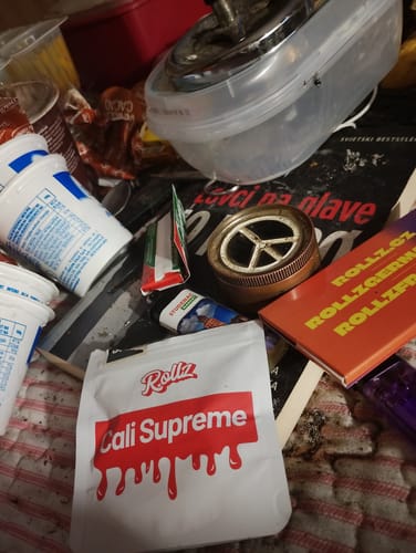 Customer's Rollz Cali Supreme THC-A flower packaging shown among scattered household items and accessories
