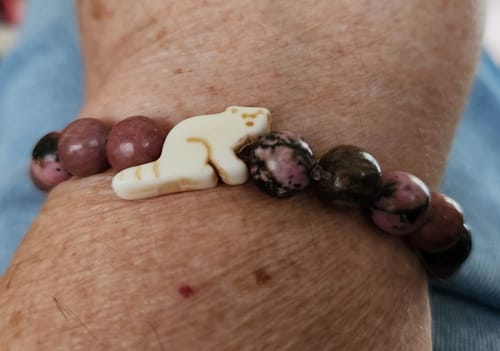 Customer's Lounge Bracelet featuring a cream koala charm and speckled marble-like beads worn on a wrist.