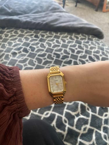 Customer's yellow gold Claire De Mains watch worn on wrist