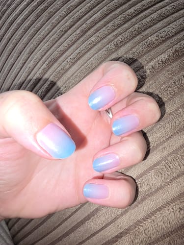 Reviewer's hand displaying Mermaid Lagoon nail gel stickers with a blue and pink gradient.
