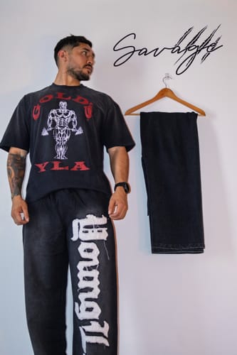 Customer's Gold's Iron Legacy Icon Tee on a person with black pants, showing the bold graphic print.