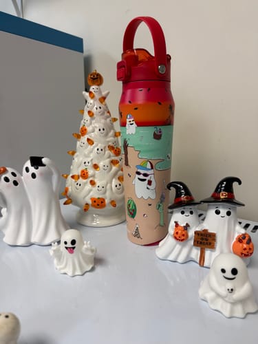 Customer's Bottle Buddy water bottle featuring a sunset and ghost beach design, displayed with spooky Halloween figures.