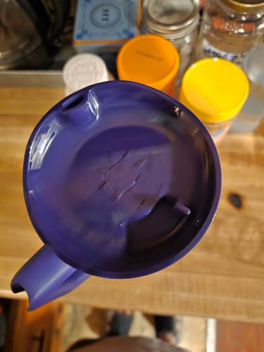 Customer's purple Thicc Buddy mug lid shown from above, resting on a wooden surface.