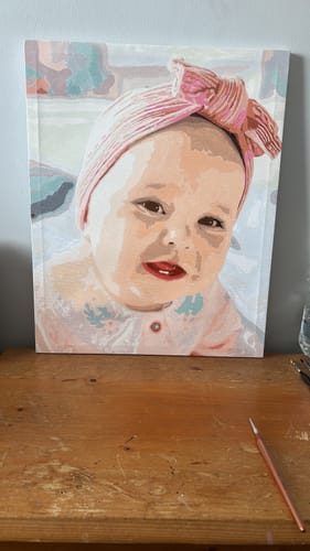Customer's Custom Paint by Numbers Kit showing a completed portrait of a baby wearing a pink headband.