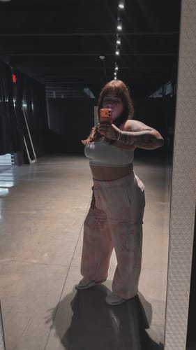 Customer's W2230 Camo Cargo Joggers in an oversized fit, worn with a white crop top in a mirror selfie.