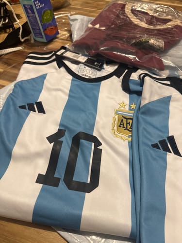 Customer's Argentina Local Fan 2022 jersey with number 10, shown with other items in original packaging.
