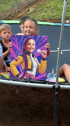 Customer's child holding a K-Pop Queen The Magic Beats personalized portrait on a trampoline.