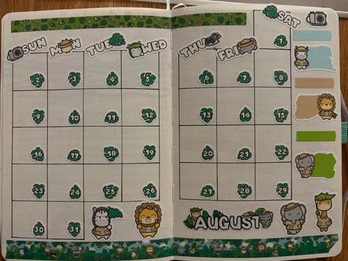Customer's journal pages from the Ultimate Subscription decorated with green safari-themed stickers and animal characters.