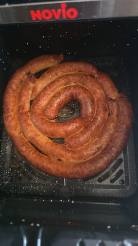 Customer's Air Fryer Novio StonePro with a coiled sausage cooking inside the black basket.