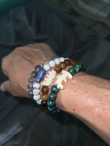 Customer's wrist wearing three beaded bracelets, including a Shark Week bracelet with a hammerhead charm.