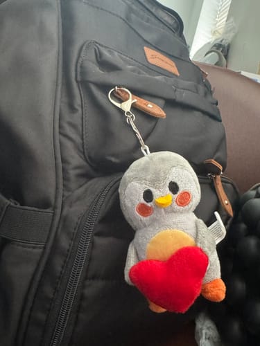 Customer's Finch Plush Bag Charm clipped to a black backpack