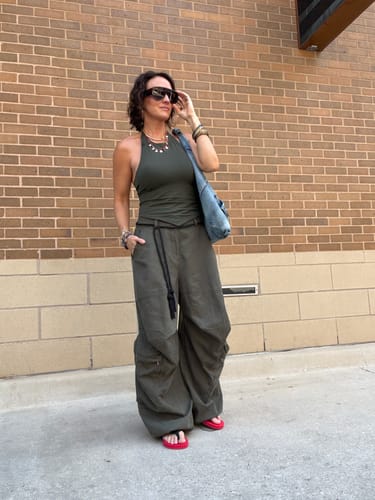 Customer's Elastic-Waist Wide-Leg Pants, worn in an oversized fit with a green top against a brick wall.