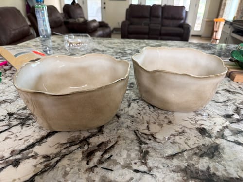 Customer's two large Crema Organic Deep Bowls with a warm reactive glaze finish, sitting on a granite countertop.