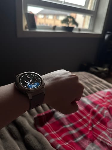 Reviewer wearing a solid Gard Pro smartwatch with a round digital face on their wrist.