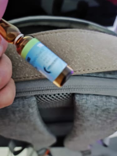 Reviewer's hand holding a small amber glass vial of Emirates Biotech Primobolan.