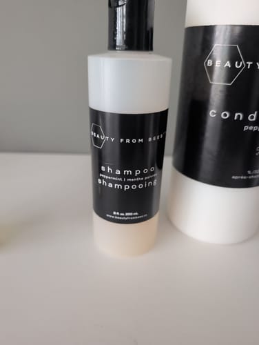 Customer's Shampoo and matching conditioner bottles on a clean surface.