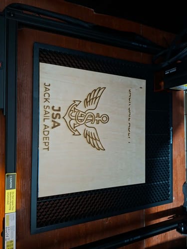 Customer's AtomStack A20 Pro V2 laser engraver with an anchor logo engraved on a wood panel.