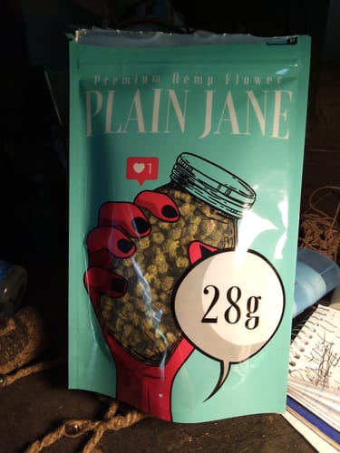 Customer's 1 Oz Cheap THCA Small Buds packaging with 28g label on a teal bag with illustrated hand holding a jar.