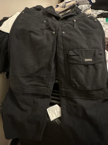 Customer's Cargo Rave Pants laid flat, showing black cargo pockets and zip-off sections.