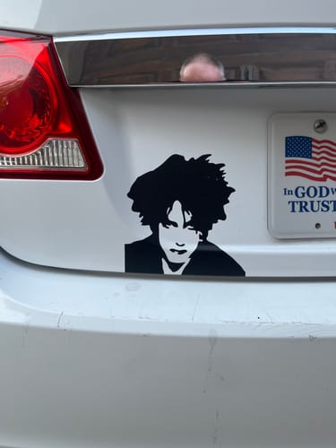 Customer's The Cure head decal applied to the white bumper of a car, showing a black Robert Smith portrait.