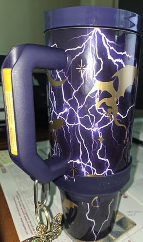 Reviewer's purple Thicc Buddy mug with lightning and dragon designs, featuring keychains attached to the handle.