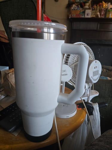 Customer's white Frost Buddy shipping protection cup with handle, lid, and straw on a desk