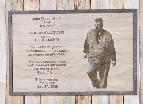 Customer's AtomStack A70 Max laser engraved wooden retirement plaque with photo and text on a rustic wood background.