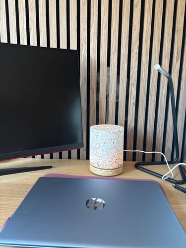 Reviewer's Living Green Geurwolkje Aroma Diffuser terrazzo, emitting mist on a desk next to a laptop.