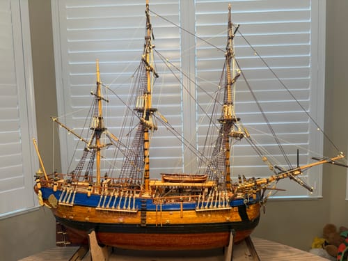 Customer's Endeavour ship model, fully assembled with wooden hull and masts, standing on display stand.