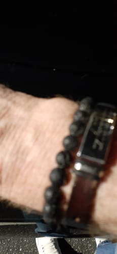 Customer's blurry, dark close-up of a Lava Beach bracelet on their wrist alongside another bracelet.