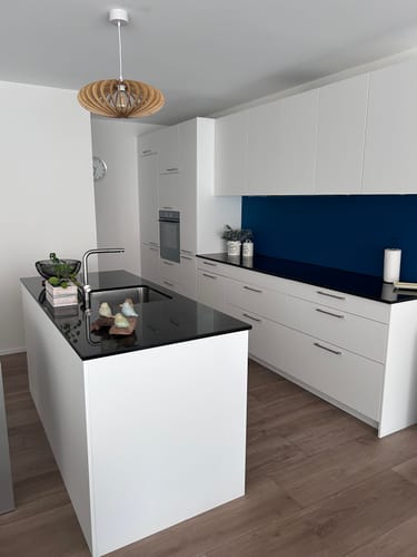 Customer's Mini NEO teinté Chêne suspension light installed over a kitchen island in a modern interior.