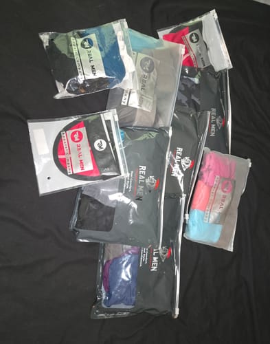 Customer's Nylon 28in Leggings in individual clear packaging, scattered on a black background.
