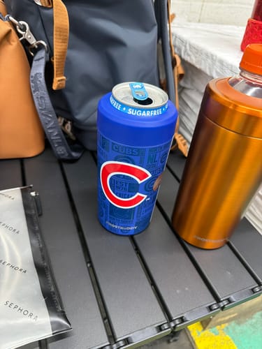 Customer's Chicago Cubs Universal Buddy can cooler holding a beverage on a table next to an orange drink holder
