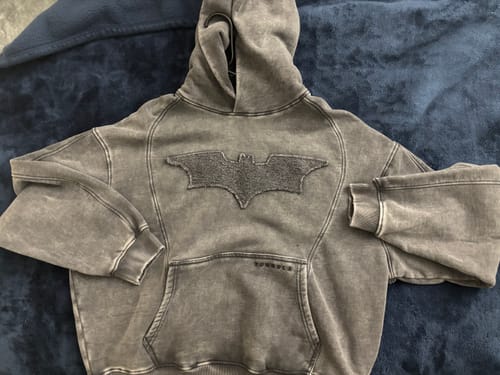 Reviewer's Batman Stealth Hoodie laid flat, showcasing the oversized, washed gray cotton design and front logo.