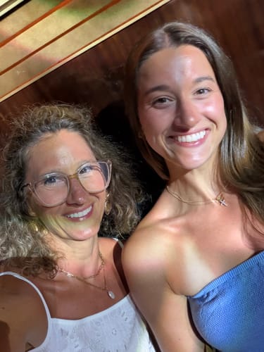 Customer's waterproof jewelry pieces worn as necklaces by two smiling people.