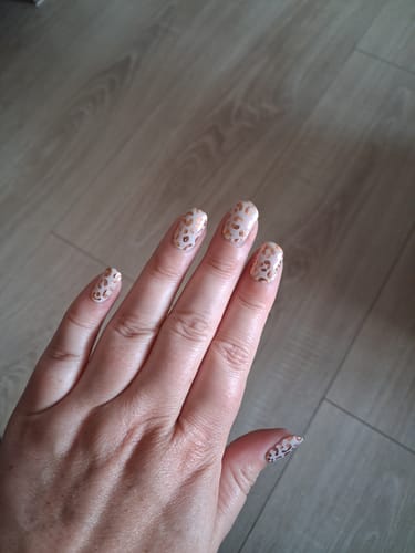 Reviewer's hand showcasing a leopard-print manicure after seven days of wear with the UV Nagellack No. 32.