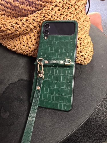Customer's green crocodile-textured leather hand strap case for Samsung Galaxy Z Flip on a table